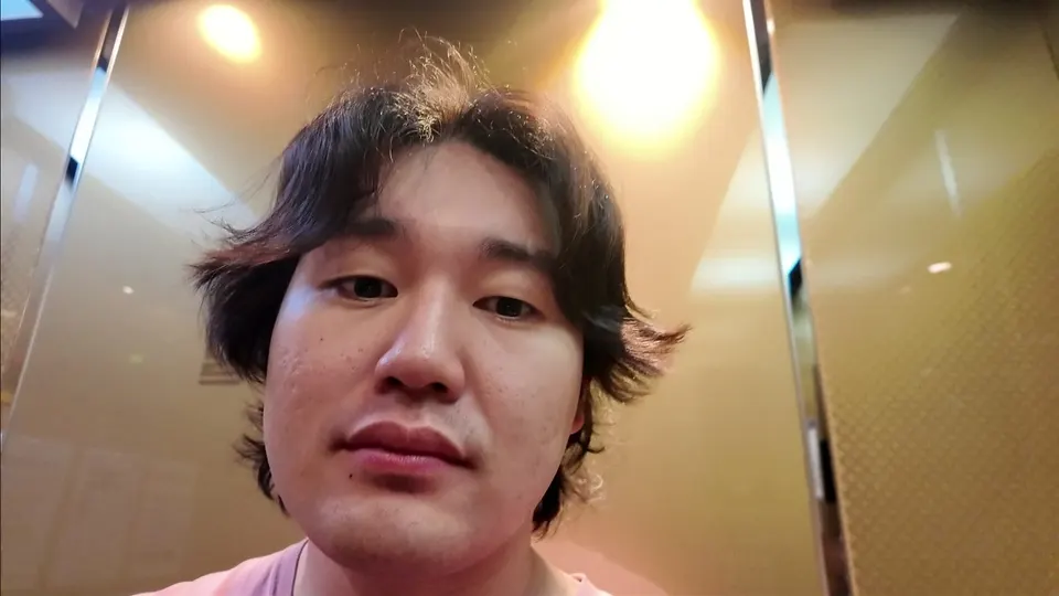 Me looking into the gold mirrored wall of my building's lift, chest camera tilted up