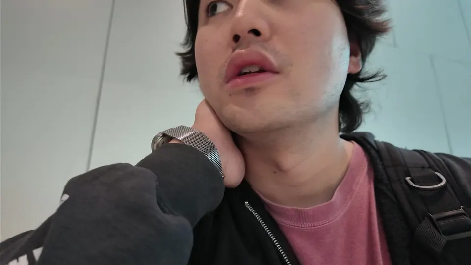 Eddie with a hand on the back of his neck, backpack straps on, in the Cam Ranh hall