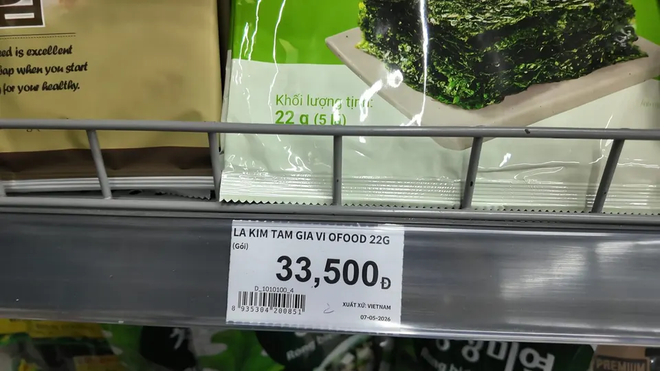 Green pack of seasoned seaweed on a shelf with a price tag below