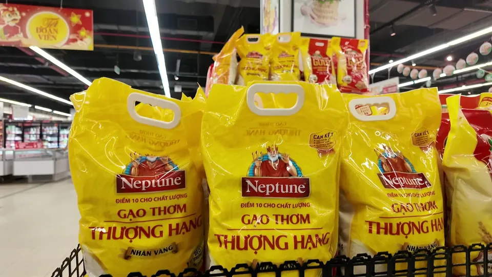 Yellow bags of Neptune fragrant rice stacked on a supermarket display